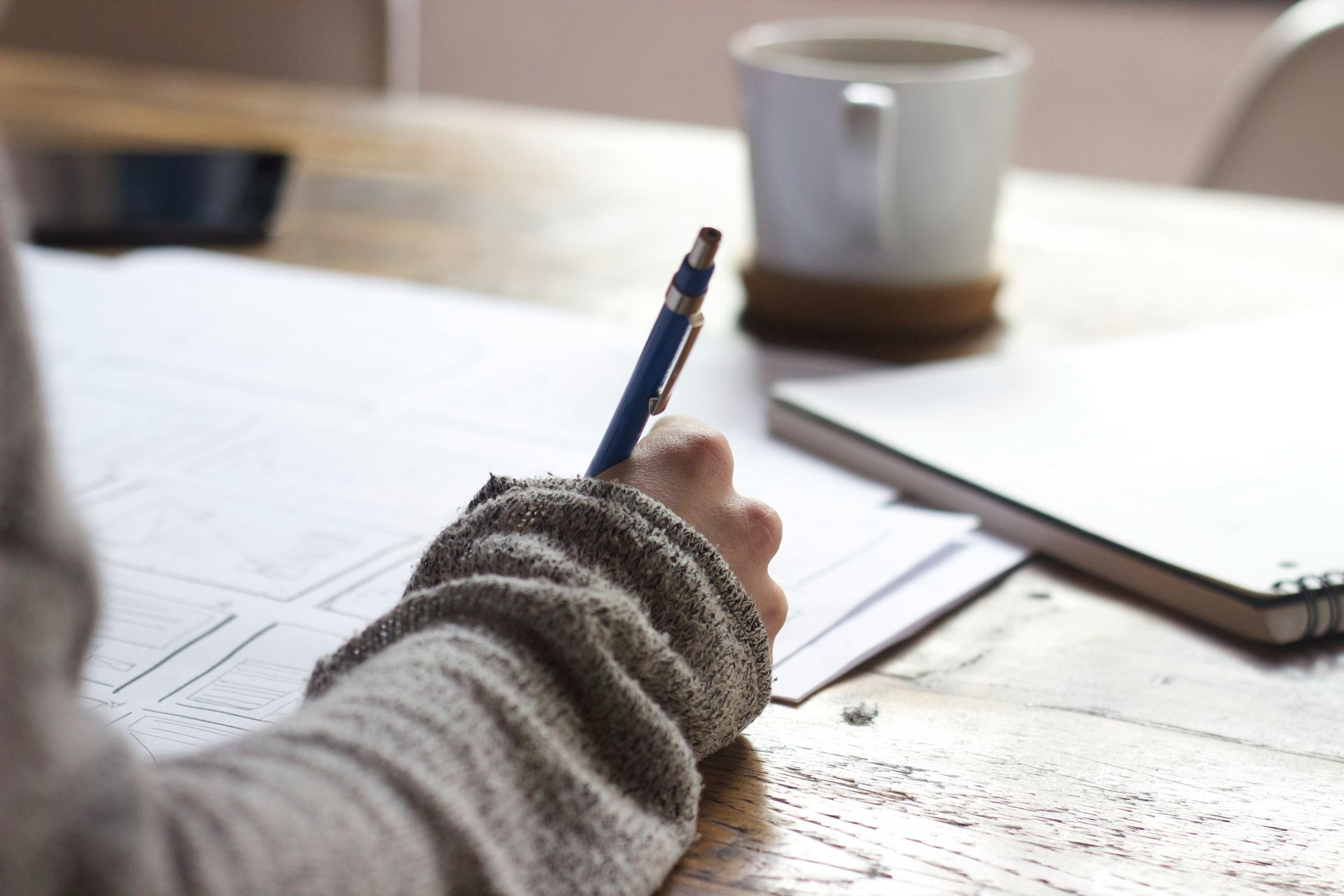 image of coffee and man holding pen